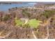 Aerial view of a beautiful home with a well-maintained lawn and a picturesque lake in the background at 16455 Harbor View Rd, Charlotte, NC 28278