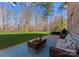 Inviting back patio area with a comfortable sofa, coffee table with snacks, and a grill, perfect for outdoor entertaining at 16455 Harbor View Rd, Charlotte, NC 28278