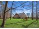 Lush backyard featuring a brick home with an outdoor play set, providing a serene setting for Gathering fun and enjoyment at 16455 Harbor View Rd, Charlotte, NC 28278