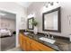 Bathroom featuring dual sinks, granite vanity, mirrors, and access to bedroom at 16455 Harbor View Rd, Charlotte, NC 28278