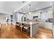 Spacious kitchen with a large granite island, hardwood floors, stainless appliances, and stylish pendant lighting at 16455 Harbor View Rd, Charlotte, NC 28278
