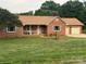 Charming brick home featuring a covered porch, lush lawn, and a convenient attached two-car garage at 1922 Dogwood Flower Ln, Lincolnton, NC 28092