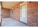 Charming front porch with brick siding and a storm door entrance at 1922 Dogwood Flower Ln, Lincolnton, NC 28092