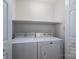 Bright laundry room with appliances and white shelving for ample storage at 1922 Dogwood Flower Ln, Lincolnton, NC 28092