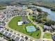 An aerial view displays a well-planned community with a pool, tennis courts, lake access, and lush greenery at 23128 Goose Down Ln, Lancaster, SC 29720