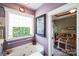 A stylish bathroom with jacuzzi tub, colorful tile window, and doorway to bedroom at 23128 Goose Down Ln, Lancaster, SC 29720