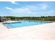 An inviting large community pool on a sunny day, surrounded by a well-maintained concrete deck and fence at 23128 Goose Down Ln, Lancaster, SC 29720