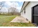 Stone patio in a grassy yard beside a white brick home, offering a cozy outdoor space with a dark stained fence at 2318 Knight Dr, Gastonia, NC 28052