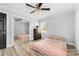 Well-lit bedroom with wood-look flooring, ceiling fan, and mirrored closet doors at 2318 Knight Dr, Gastonia, NC 28052