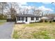 Inviting white brick home with a well-manicured lawn, black shutters, and a welcoming front door with wreath at 2318 Knight Dr, Gastonia, NC 28052