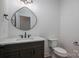 Stylish half-bathroom featuring modern fixtures, vanity, decorative mirror, and toilet at 2321 Ivey Church Rd, Maiden, NC 28650
