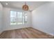 Cozy bedroom with large windows and a view to the outdoors, featuring warm wood flooring and modern lighting at 2321 Ivey Church Rd, Maiden, NC 28650