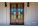 Close-up of the front door with wood frame, glass panels, and modern lighting at 2321 Ivey Church Rd, Maiden, NC 28650