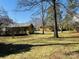 Large yard view of home exterior featuring trees, grass, and a deck at 300 Mcalway Rd, Charlotte, NC 28211