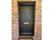 Close-up of a stylish black front door with gold accents and brick surround at 300 Mcalway Rd, Charlotte, NC 28211