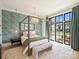 Serene bedroom featuring a four-poster bed, statement chandelier, and expansive window views at 3203 Maymont Pl, Charlotte, NC 28205