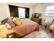 Cozy bedroom with wood floors, black accent wall, large windows, and warm yellow and peach tones at 4342 Valeview Ln, Charlotte, NC 28269