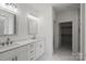 Bathroom featuring dual sinks, white cabinets, and a walk-in closet at 501 Everette St, Monroe, NC 28112