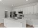 Bright kitchen with stainless appliances, island sink, and white cabinetry at 501 Everette St, Monroe, NC 28112