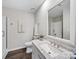 Well-lit bathroom featuring a marble vanity, shower, and decorative art at 5530 Great Wagon Rd, Charlotte, NC 28215