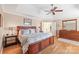 Comfortable bedroom features hardwood flooring, a trey ceiling with ceiling fan, and a large bed at 6141 Abergele Ln, Matthews, NC 28104