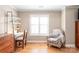 Bright bedroom featuring hardwood floors, a large window, and a comfortable seating area with a chair at 6141 Abergele Ln, Matthews, NC 28104