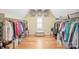 Walk-in closet featuring custom shelving, ample storage, and hardwood floors at 6141 Abergele Ln, Matthews, NC 28104