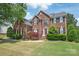 Stately brick home with manicured lawn and lush landscaping at 6141 Abergele Ln, Matthews, NC 28104