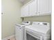 Bright laundry room equipped with new washer and dryer beneath ample storage cabinets at 6141 Abergele Ln, Matthews, NC 28104
