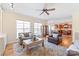 Open-concept living room featuring a ceiling fan, hardwood floors, a neutral color palette and access to kitchen at 6141 Abergele Ln, Matthews, NC 28104
