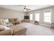 Spacious living room with plush sectional sofa, large windows, and a ceiling fan at 6141 Abergele Ln, Matthews, NC 28104
