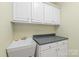 Functional utility sink with countertop and ample cabinets in a well-lit space at 6141 Abergele Ln, Matthews, NC 28104