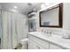 Clean bathroom featuring a decorative shower curtain, a vanity with towels, and a large mirror at 667 Portside Dr, Davidson, NC 28036