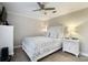 Bright bedroom with a ceiling fan, white furniture, and soothing gray and white patterned bedding at 667 Portside Dr, Davidson, NC 28036