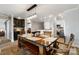 Open-concept dining room with a rustic table, wooden chairs, a stylish light fixture, and views of the kitchen at 667 Portside Dr, Davidson, NC 28036