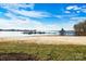 Beautiful lake view with a sandy beach, a gazebo, and a dock with boats under a bright blue sky with clouds at 667 Portside Dr, Davidson, NC 28036