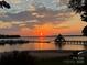 Picturesque lake view with boats docked, a gazebo on the water, and a stunning sunset at 667 Portside Dr, Davidson, NC 28036