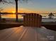 Stunning lake view at sunset with a dock, gazebo, and chair on the deck at 667 Portside Dr, Davidson, NC 28036