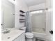 Bright bathroom with shower-tub combo, single sink vanity, toilet, and decorative floating shelves at 7507 Reedy Creek Rd, Charlotte, NC 28215