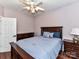 Cozy bedroom featuring a wooden bed frame, dresser, and a ceiling fan with light fixture at 7507 Reedy Creek Rd, Charlotte, NC 28215