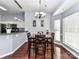 Dining area with hardwood floors and adjacent kitchen featuring modern lighting and ample natural light from the window at 7507 Reedy Creek Rd, Charlotte, NC 28215