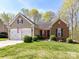 Traditional home with brick and siding, a two-car garage, and a green front lawn at 7507 Reedy Creek Rd, Charlotte, NC 28215