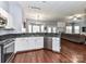 Open kitchen with stainless steel dishwasher, granite countertops, wooden floors, and open access to the living room at 7507 Reedy Creek Rd, Charlotte, NC 28215