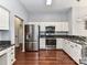 Well-lit kitchen featuring stainless steel appliances, granite countertops and wooden floor at 7507 Reedy Creek Rd, Charlotte, NC 28215
