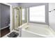 Main bathroom with separate shower and tub, window for natural light, and neutral color palette at 7507 Reedy Creek Rd, Charlotte, NC 28215