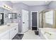 Spacious bathroom featuring a shower, tub, double sink vanity, and neutral paint at 7507 Reedy Creek Rd, Charlotte, NC 28215