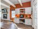 Bright home office with white cabinets, built-in desk and drawers, and rustic wood floors, next to a fire place at 8112 Bush Mill Ln, Charlotte, NC 28270