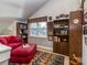 Cozy loft space with a red couch, ottoman, and built-in shelving, creating a comfortable and inviting atmosphere at 8112 Bush Mill Ln, Charlotte, NC 28270