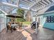 Inviting backyard patio with a pergola, an outdoor dining set, a grill, and lush greenery, ideal for entertaining at 8112 Bush Mill Ln, Charlotte, NC 28270