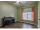 Well-lit bedroom with wood-look flooring, ceiling fan, and piano at 8828 Powder Works Dr, Huntersville, NC 28078